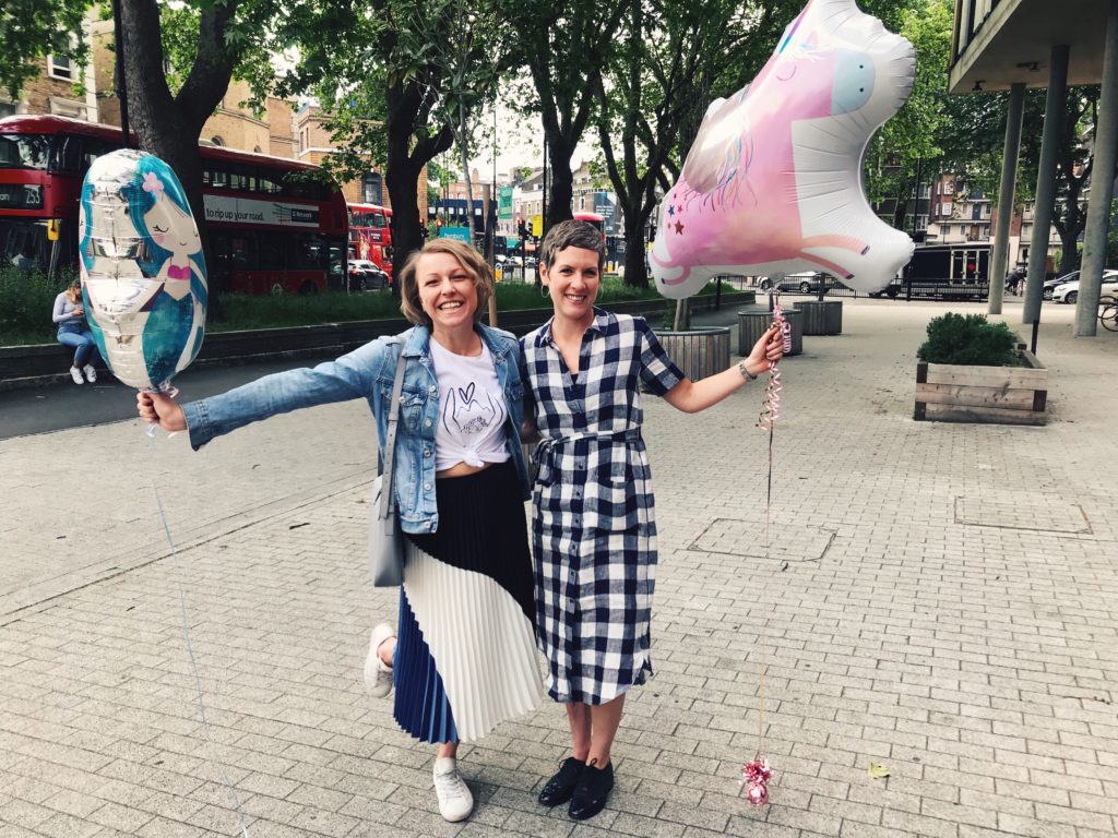 Two women smiling with birthday balloons