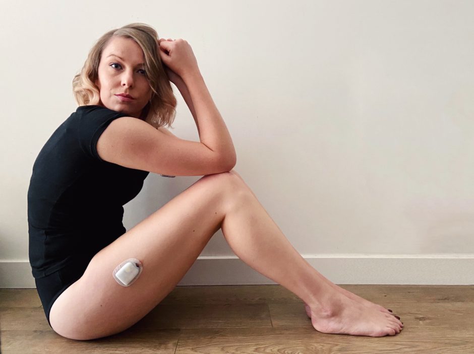 missjengrieves sat on the floor displaying her insulin pump on her upper thigh