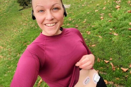 Jen Grieves out running holding up her running top to show a Dexcom and Omnipod stuck to her abdomen