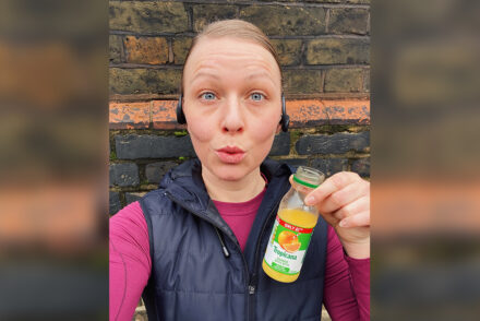 Jen Grieves out running holding up a carton of orange to fix hypoglycaemia